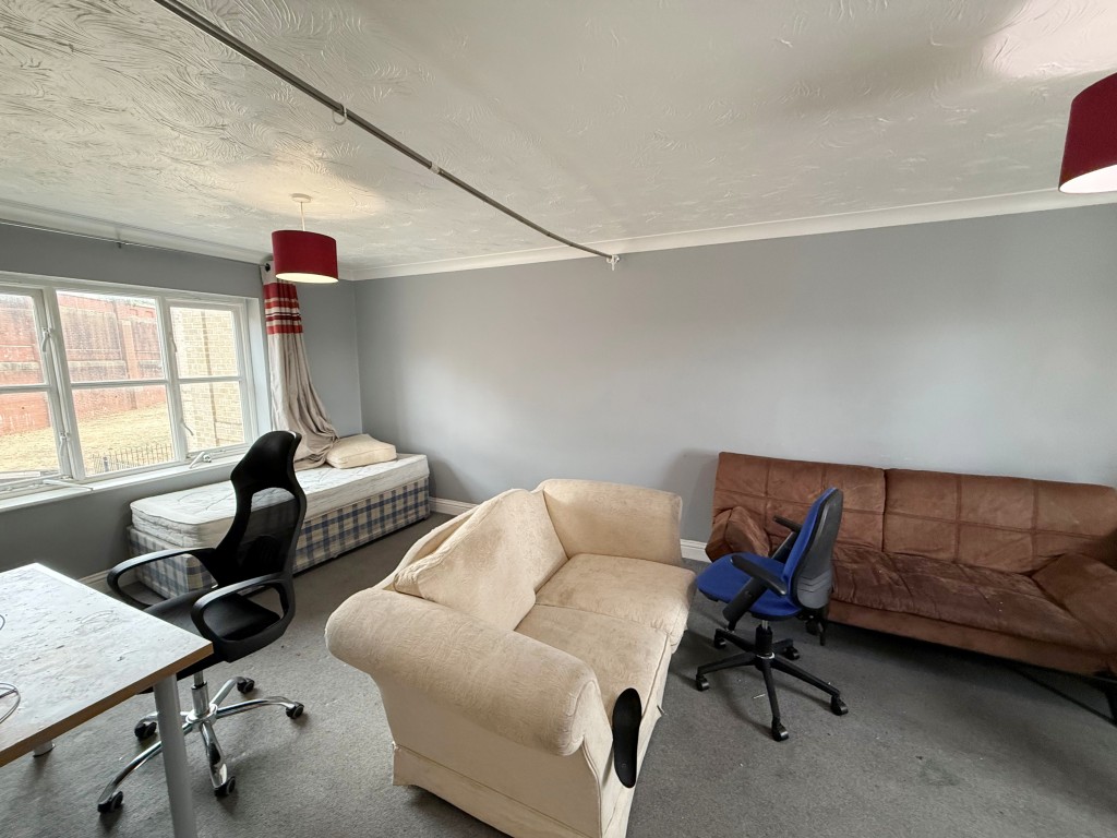 Lot: 36 - TWO-BEDROOM FIRST FLOOR FLAT FOR IMPROVEMENT - First view of lounge/dining room with carpet and window